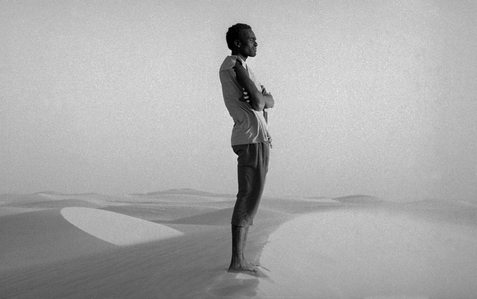 Card stoic man on sand dune